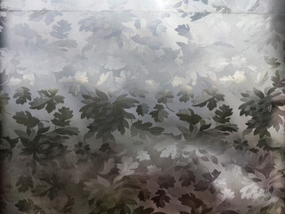 Abstract Plastic or oilcloth gray background and texture with spots, leaves. Pattern, frame, place...