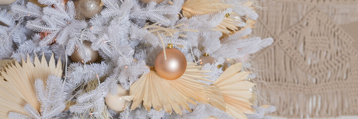 Close up of beautiful white fir branches with shiny golden, silver and white baubles or balls, shiny ornaments and garland lights, home Decoration.Festive new 2024 year. web banner.