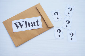 Word cards with question word What on brown envelope and cards of question marks. Concept. Teaching aid. Education materials for teach WH- question. Asking questions. Suspicious symbol to find answer.