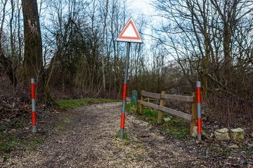 Fototapeta na wymiar Prohibition of entering the forest with barrier and warning triangle sign