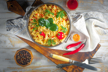 Pasta, spaghetti in a plate with seasonings and vegetables. Hot, natural and tasty dish.