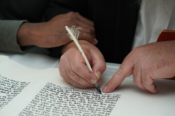 hand writing of a Jewish Torah scroll with a quill or feather according to ancient Jewish tradition.