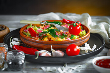 Pasta, spaghetti in a plate with seasonings and vegetables. Hot, natural and tasty dish.