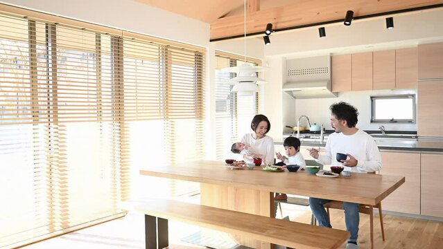 Happy smiling family eating at the table of a beautiful house Wide angle video　 