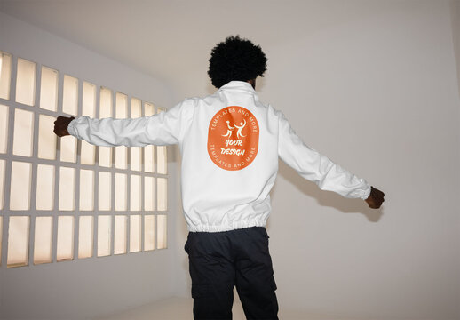 Mockup of man wearing customizable jacket with arms out, camera flash