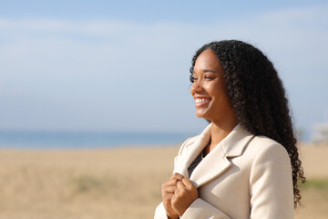 Happy black woman on the beach in winter