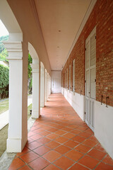 Long straight narrow passage of a building with brick wall