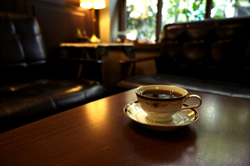 A cup of coffee on table in a dark coffee shop
