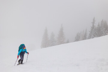Fototapeta na wymiar Climber in the mountains. A girl walks through the snow in the mountains.