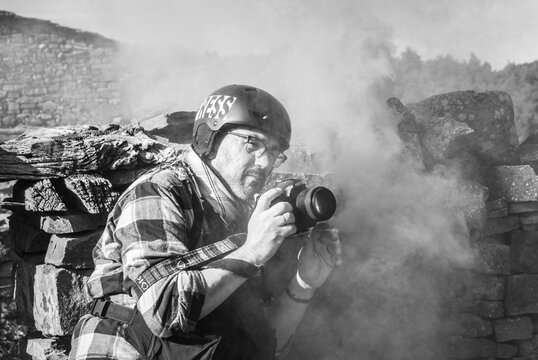 Photojournalist documenting war conflict. in the mountains. concept of war, military, technology and journalistic work.
