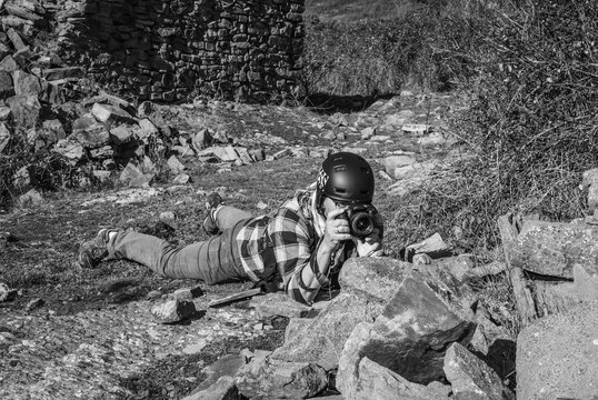Photojournalist documenting war conflict. in the mountains. concept of war, military, technology and journalistic work.

