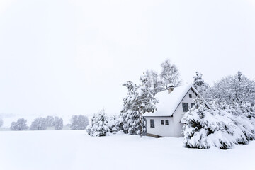Snow covered suburban gray cottage after strong snowfall. Europe.