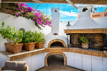 A charming al fresco scene unfolds with an open-air white stone oven and BBQ, skillfully bordered...