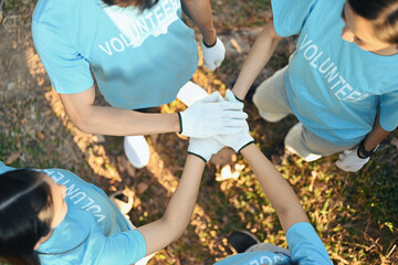 Group of volunteers stacking their hands together showing the power of unity in charity work