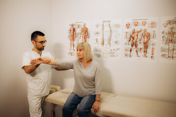 Professional chiropractor, osteopath or physiotherapist working with senior female patient. Male manual therapy specialist at modern health center massaging old lady's neck and shoulders - obrazy, fototapety, plakaty
