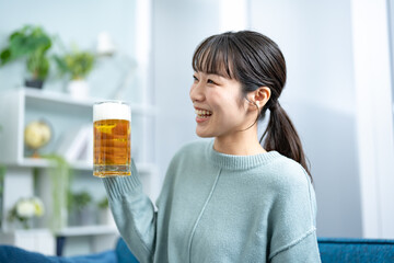 リビングでビールを持つ女性