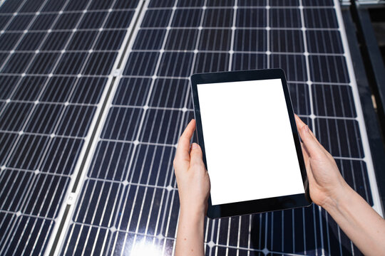 Hands with digital tablet on a background of solar panels