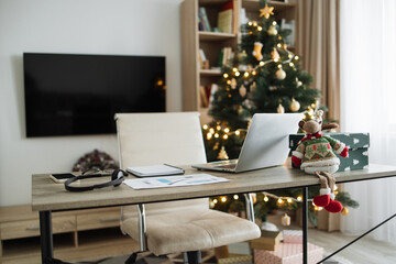 Modern laptop computer on wood table. Cozy comfortable home living room with Christmas decor. Home office desk workspace. Mockup copy space. Winter sales, online shopping