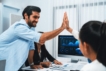 Analyst team leader celebrate and high five together with his colleague after successful data...