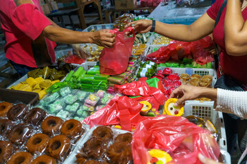 Many varieties of traditional snacks sold in the Marketplace in dawn time in Surabaya, East Java, Indonesia. - obrazy, fototapety, plakaty