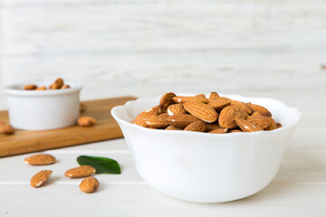 Fresh healthy Almond in bowl on colored table background. Top view