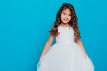 Fototapeta na wymiar Girl in white elegant dress on a blue background Holiday
