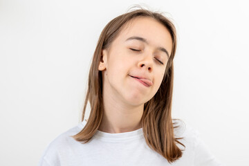 Funny teenage girl licks her lips on a white background isolated.