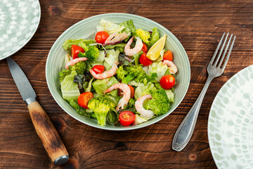 Salad with broccoli, mixed greens and prawn.