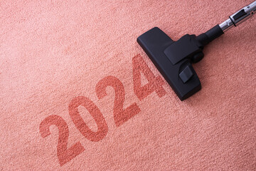 2024 New year home cleaning with vacuum cleaner and copy space for a text