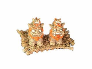 日本沖縄の代表的なお土産であるシーサーの置き物。 白い背景と幸運を呼ぶ笑顔のライオン。