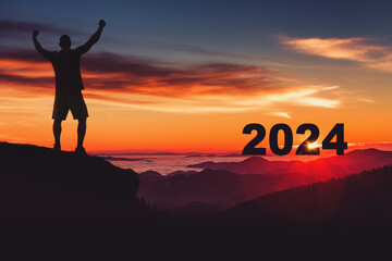 Man silhouette on the mountain top watching the sunrise and 2024 years while celebrating