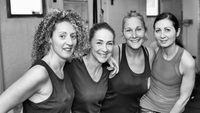 Four happy women after doing trx training at the gym