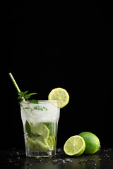 Glass with mojito cocktail and limes