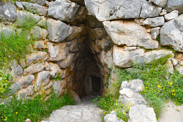 Entrance to dark passage under the ancient walls. UNESCO World Heritage Site. Ruins of Mycenae, center of Greek civilization, Peloponnese, Greece. Mycenae is a famous archaeological site in Greece. 