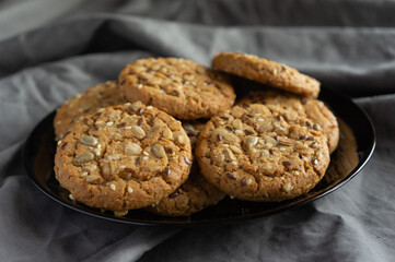 oatmeal cookies on a black plate on a gray fabric background