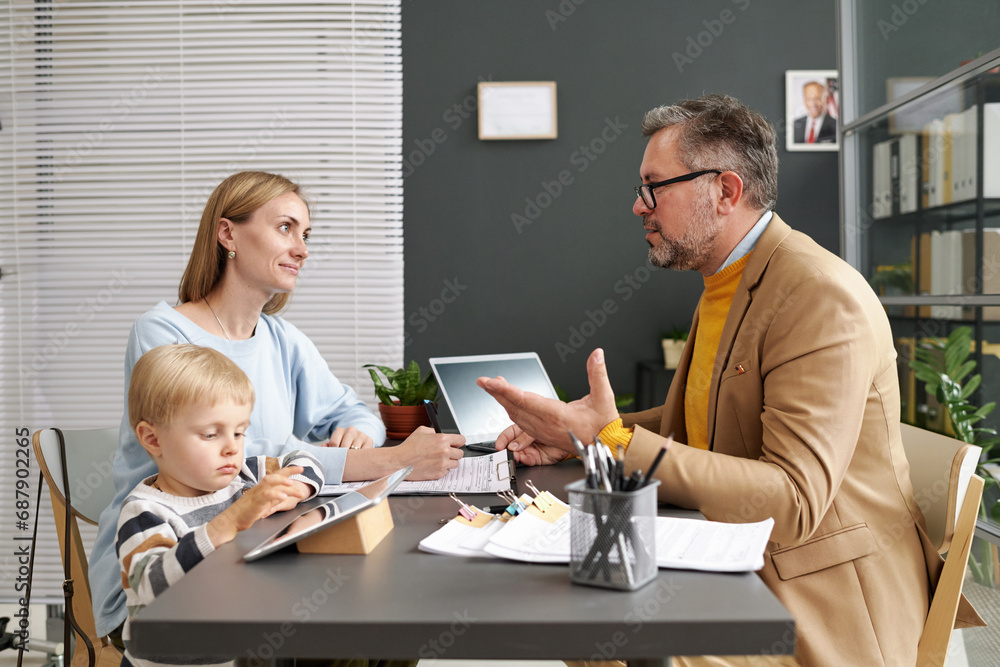 Wall mural social worker talking to young woman about adoption during their meeting in office