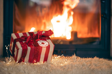 Christmas gift box by the fireplace, copy space.