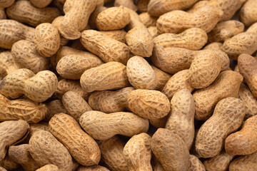 Food background of peanuts in shell, top view. Heap of fresh peanuts