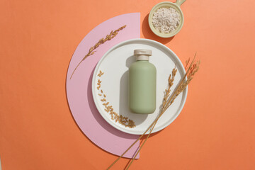 Ceramic dish in round shaped with unbranded bottle placed on with wheat ears. A bowl of rice bran...
