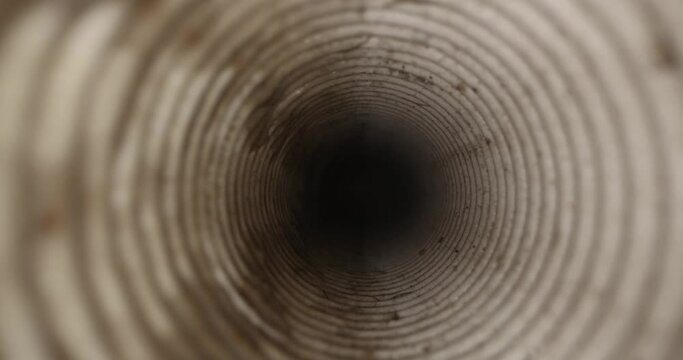 sliding inside dirty corrugated drainage pipe