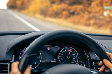 Steering wheel in a car close up, high speed driving on the road.