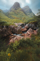 Moody, atmospheric mountain landscape along the River Coe to the Three Sisters of Glencoe  in the Scottish Highlands, Scotland. - obrazy, fototapety, plakaty