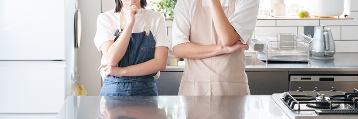 Obraz premium キッチンで考える夫婦（料理・家事）