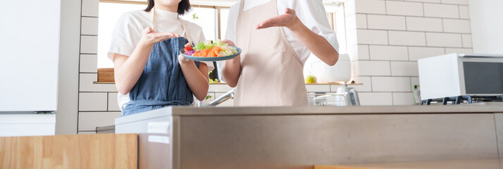 キッチンで笑顔の夫婦（料理・家事）