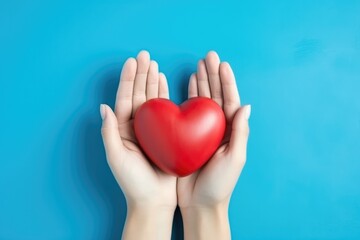Fototapeta premium Hands Hold Heart On Blue Background Highquality Photo. Сoncept Heart-Shaped Hands, Blue Background, High-Quality Photo, Symbolic Gesture