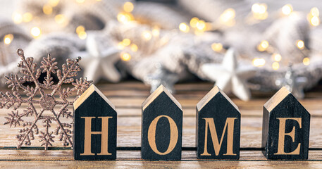 Cozy background with decorative word Home on a blurred background with garland.