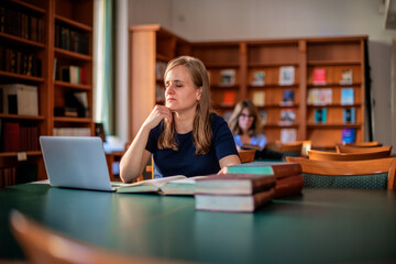 A visually impaired woman sitting and studying in the university library