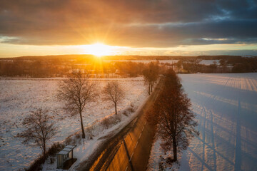 Aerial landscape of the road through snowy field at winter, Poland. - obrazy, fototapety, plakaty