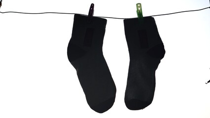 drying socks after washing, hanging on a clothesline with clothespins on a light background