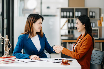 Consultation between a female lawyer and business customer, handshake after good deal agreement,...
